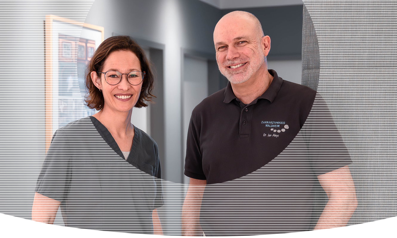 Zahnärztin Frau Julia Hilbert und Herr Dr. Jan Aleyt lächeln in die Kamera.